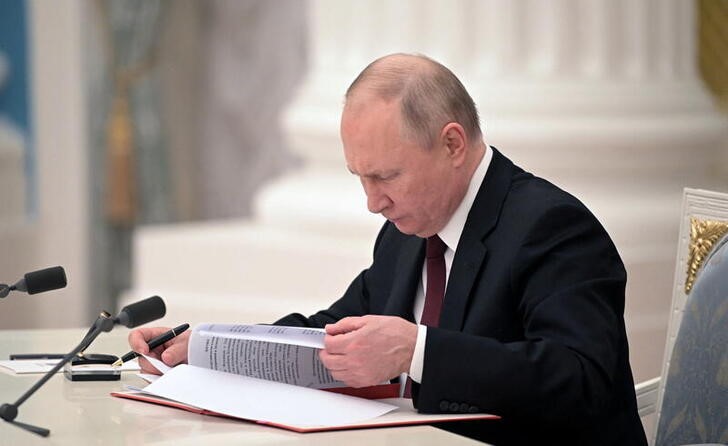 &copy; Reuters. Russian President Vladimir Putin signs documents, including a decree recognising two Russian-backed breakaway regions in eastern Ukraine as independent entities, during a ceremony in Moscow, Russia, in this picture released February 21, 2022. Sputnik/Alex