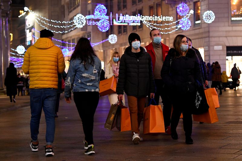 &copy; Reuters. FILE PHOTO: People wearing protective face masks walk along a shopping street as the government prepares to bring in further restrictions over the Christmas period to curb the spread of the coronavirus disease (COVID-19) in Milan, Italy, December 18, 2020
