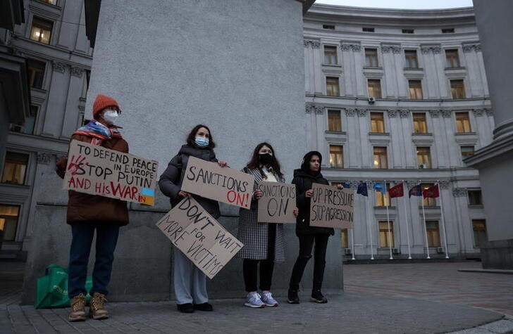 &copy; Reuters. Activists hold banners in front the Ukrainian Foreign Ministry as they demand European Union to improve additional sanctions against Russia, in central Kyiv, Ukraine February 21, 2022. REUTERS/Umit Bektas
