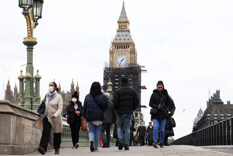 &copy; Reuters. FILE PHOTO: People wearing protective face masks walk over Westminster Bridge in front of the Elizabeth Tower, more commonly known as Big Ben, in London, Britain, December 15, 2021. REUTERS/Henry Nicholls