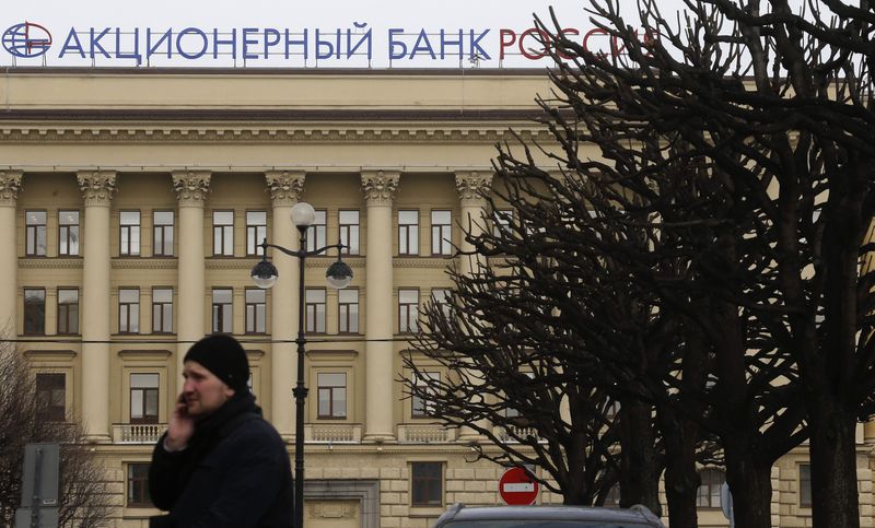 © Reuters. A man walks past the head office of Bank Rossiya in St. Petersburg March 21, 2014. REUTERS/Alexander Demianchuk/Files