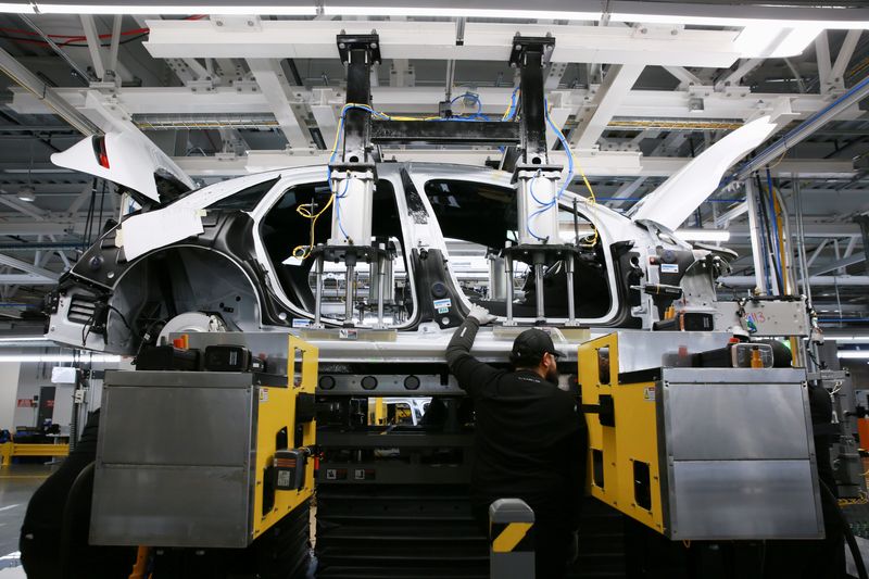 &copy; Reuters. FILE PHOTO - Workers marry the body structure with the battery pack and the front and rear sub frames as they assemble electric vehicles at the Lucid Motors plant in Casa Grande, Arizona, U.S. September 28, 2021.  REUTERS/Caitlin O'Hara