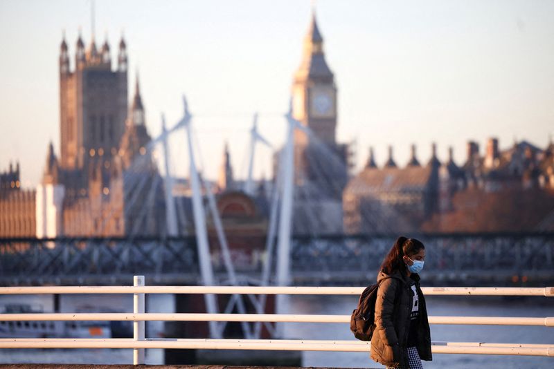 &copy; Reuters. FILE PHOTO: A person wearing a protective face mask walks over Waterloo Bridge during morning rush hour, amid the ongoing coronavirus disease (COVID-19) pandemic in London, Britain, January 21, 2022. REUTERS/Henry Nicholls
