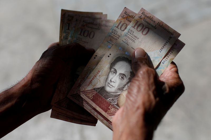 &copy; Reuters. FILE PHOTO: A man counts Venezuelan bolivar notes in downtown Caracas, Venezuela January 9, 2018. REUTERS/Marco Bello
