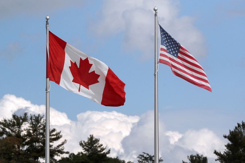 &copy; Reuters. FILE PHOTO: A U.S. and a Canadian flag flutter at the Canada-United States border crossing at the Thousand Islands Bridge, which remains closed to non-essential traffic to combat the spread of the coronavirus disease (COVID-19) in Lansdowne, Ontario, Cana