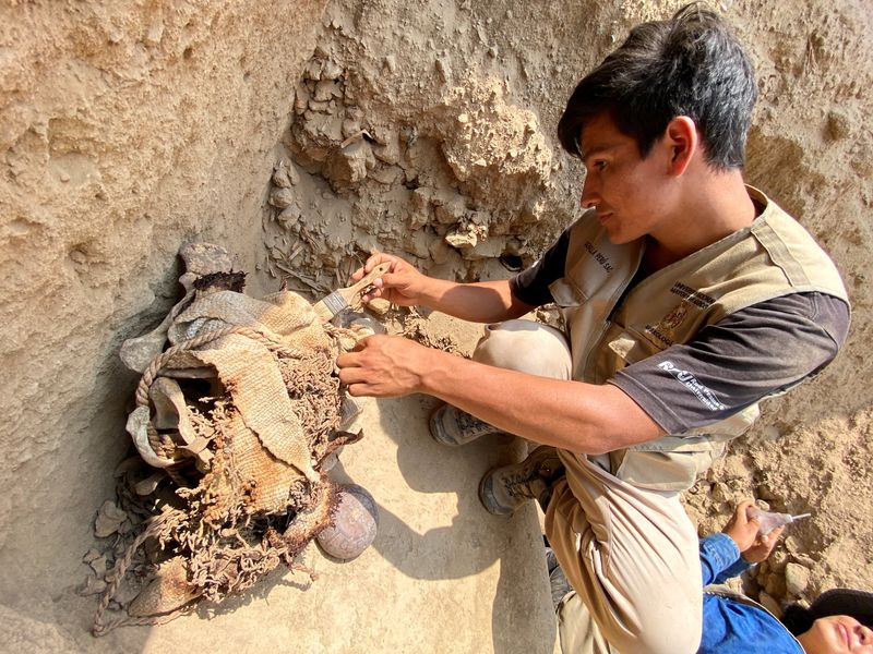 &copy; Reuters. FOTO DE ARCHIVO-Un arqueólogo peruano trabaja en una excavación para recuperar los restos de 14 momias preincas, seis niños y ocho adultos que tienen casi 1000 años de antigüedad, en el complejo arqueológico de Cajamarquilla, Perú. 13 de febrero de