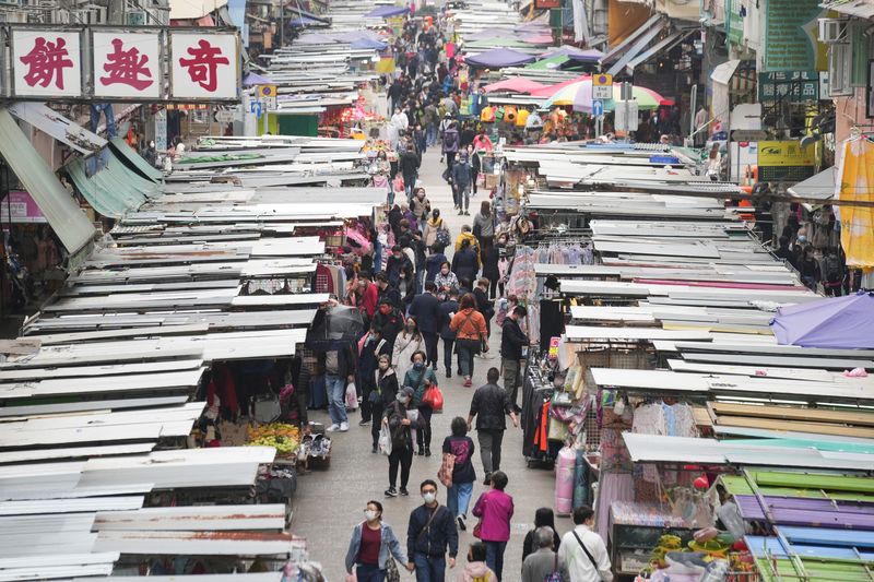 &copy; Reuters. People wearing face masks, following the coronavirus disease (COVID-19) outbreak, walk on a street market in Hong Kong, China February 16, 2022. REUTERS/Lam Yik
