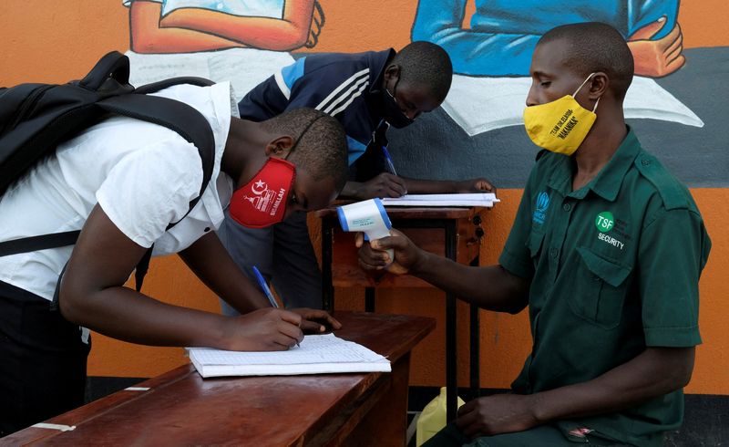 &copy; Reuters. FOTO DE ARCHIVO: Dos estudiantes apuntan sus datos para someterse a una medición de temperatura en la escuela secundaria Bukere de el campamento de refugiados Kyaka II del distrito de Kyegegwa, Uganda, el 11 de enero de 2022. REUTERS/Esther Ruth Mbabazi