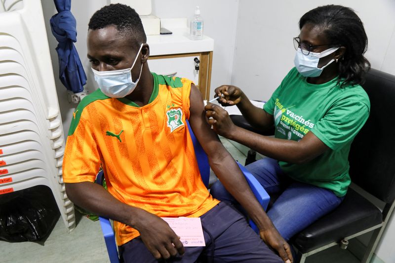 &copy; Reuters. Torcedor da seleção da Costa do Marfim recebe vacina contra Covid-19 antes de assistir à partida da equipe em telão em Abidjan
12/01/2022 REUTERS/Luc Gnago