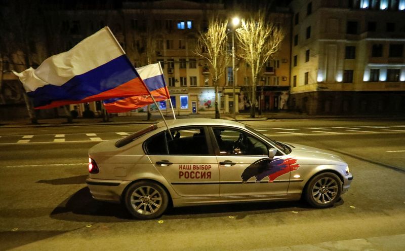 &copy; Reuters. سيارة ترفع علمين روسيين في دونيتسك يوم 21 فبراير شباط 2022. تصوير: ألكسندر إيرموتشينكو - رويترز