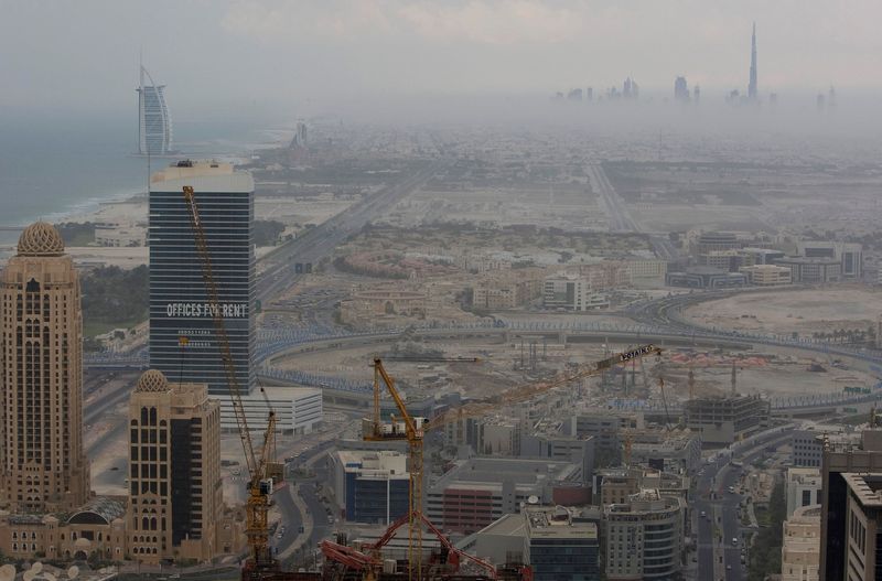 &copy; Reuters. FILE PHOTO: An early evening view of the Burj Dubai (top right) and Burj Al Arab (back left) with construction work in the foreground, late November 15, 2008.  REUTERS/Steve Crisp