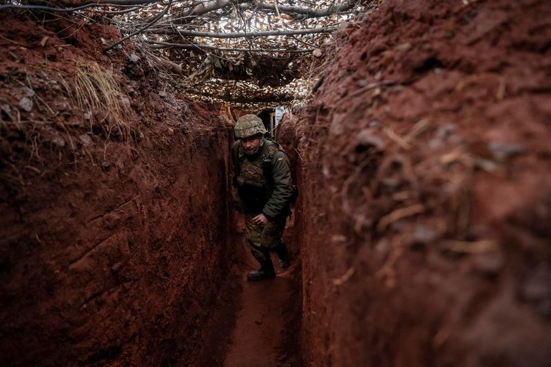 &copy; Reuters. A Ukrainian service member walks along a trench at a position on the front line near the city of Novoluhanske in the Donetsk region, Ukraine February 22, 2022. REUTERS/Gleb Garanich  