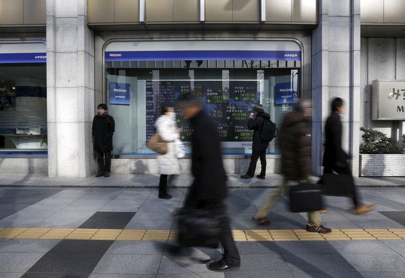 &copy; Reuters. FILE PHOTO: A pedestrian looks an electronic board showing the stock market indices of various countries outside a brokerage in Tokyo, Japan, February 3, 2016. REUTERS/Yuya Shino