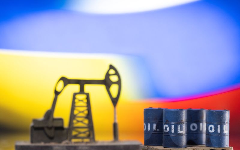 &copy; Reuters. Models of oil barrels and a pump jack are displayed in front of Ukrainian and Russian flag colors in this illustration taken, February 24, 2022. REUTERS/Dado Ruvic/Illustration 