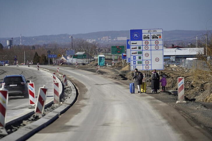 &copy; Reuters. Foto del jueves de una familia que huye de Ucrania cruzando la frontera con Polonia en Medyka
Feb 24, 2022. REUTERS/Bryan Woolston