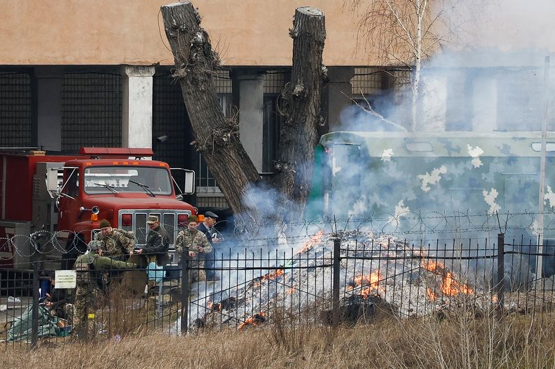 &copy; Reuters. Pessoal uniformizado em meio a incêndio no prédio de inteligência no complexo do Ministério da Defesa da Ucrânia em Kiev
24/02/2022 REUTERS/Umit Bektas