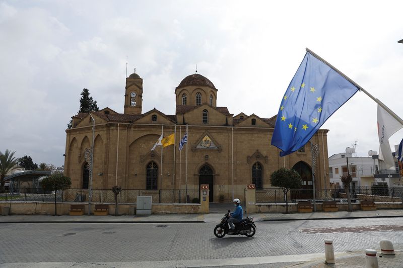 &copy; Reuters. A man rides his motorcycle in front of the church of St. George in the Ayios Dhometios suburb of Nicosia, Cyprus February 24, 2022. REUTERS/Yiannis Kourtoglou