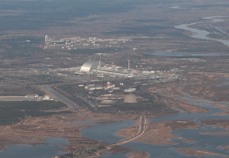 &copy; Reuters. FILE PHOTO: An aerial view from a plane shows a New Safe Confinement (NSC) structure over the old sarcophagus covering the damaged fourth reactor at the Chernobyl Nuclear Power Plant during a tour to the Chernobyl exclusion zone, Ukraine April 3, 2021. RE