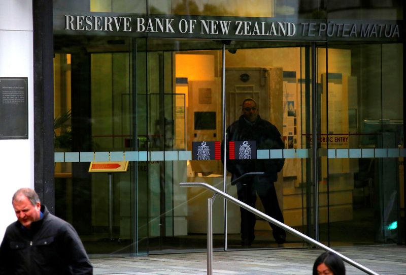 &copy; Reuters. FILE PHOTO: Pedestrians walk past as a security guard stands in the main entrance to the Reserve Bank of New Zealand located in central Wellington, New Zealand, July 3, 2017. REUTERS/David Gray