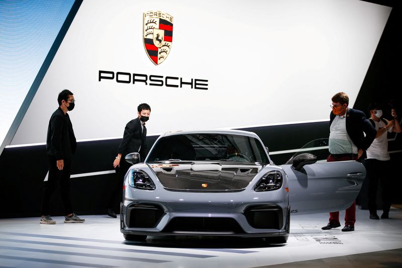 © Reuters. FILE PHOTO: Attendees look at the 2022 Porsche 718 Cayman GT4 RS during the 2021 LA Auto Show in Los Angeles, California, U.S. November 17, 2021. REUTERS/Ringo Chiu
