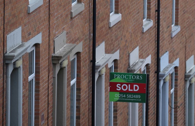 &copy; Reuters. FILE PHOTO: An estate agent's board is displayed outside a house on a terraced street in Blackburn, Britain, January 17, 2022. Picture taken January 17, 2022. REUTERS/Phil Noble/