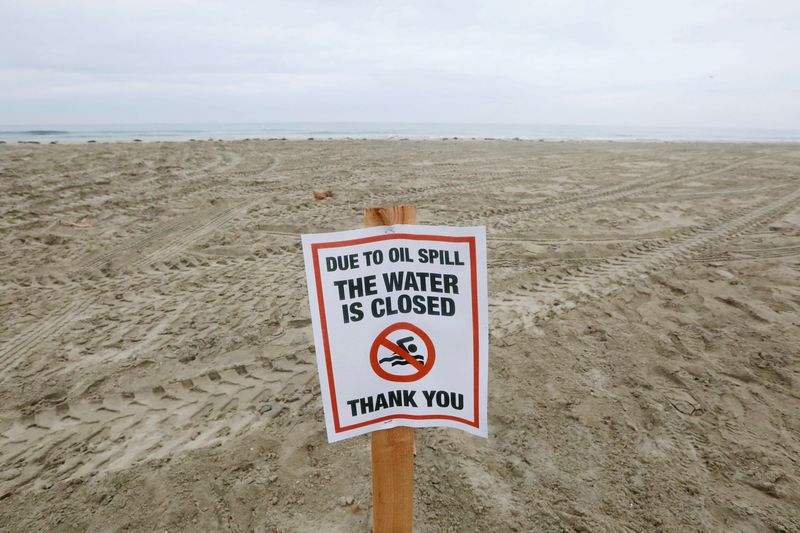 &copy; Reuters. FILE PHOTO: A sign indicating that the beach is closed is seen as workers rake up crude oil, after more than 3,000 barrels (126,000 gallons) of crude oil leaked from a ruptured pipeline into the Pacific Ocean in Newport Beach, California, U.S., October 7,