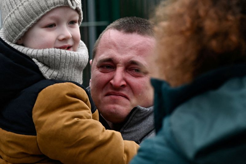 © Reuters. رجل يبكي وهو يحمل طفلا لدى وصوله إلى اولبا بسلوفاكيا يوم الجمعة قادما من أوكرانيا.تصوير: رادوفان ستوكلاسا-رويترز.