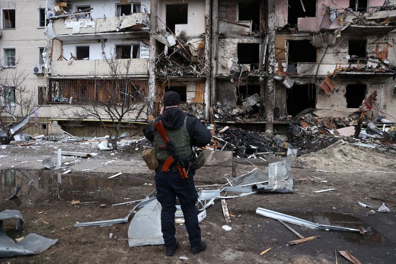 © Reuters. رجل يقف أمام مبنى سكني مدمر في كييف بأوكرانيا يوم الجمعة. تصوير: أوميت بيكطاش-رويترز.