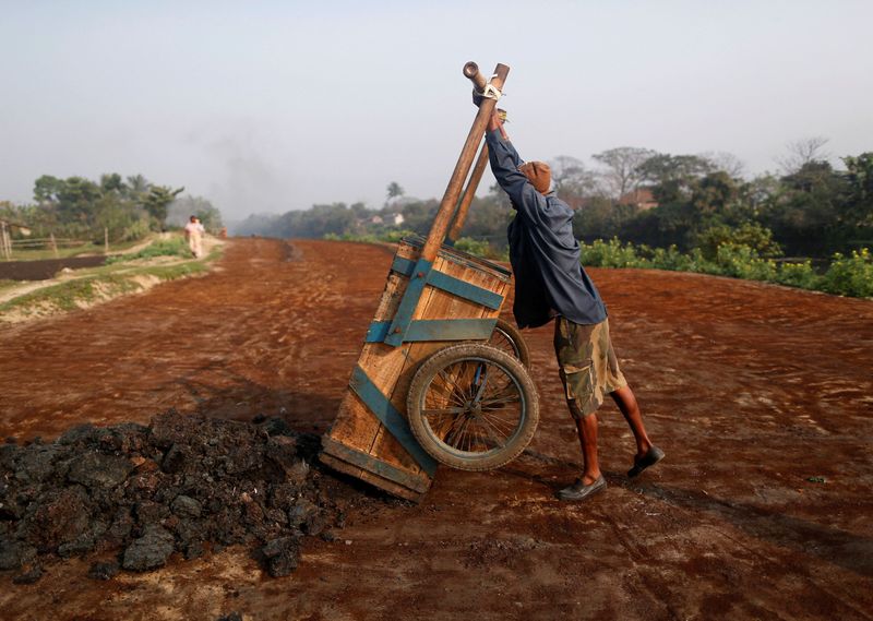 © Reuters. FILE PHOTO: A labourer unloads fertilizer for drying at a factory which makes fertiliser ingredients out of scrap leather in Kolkata February 14, 2014. REUTERS/Ahmad Masood