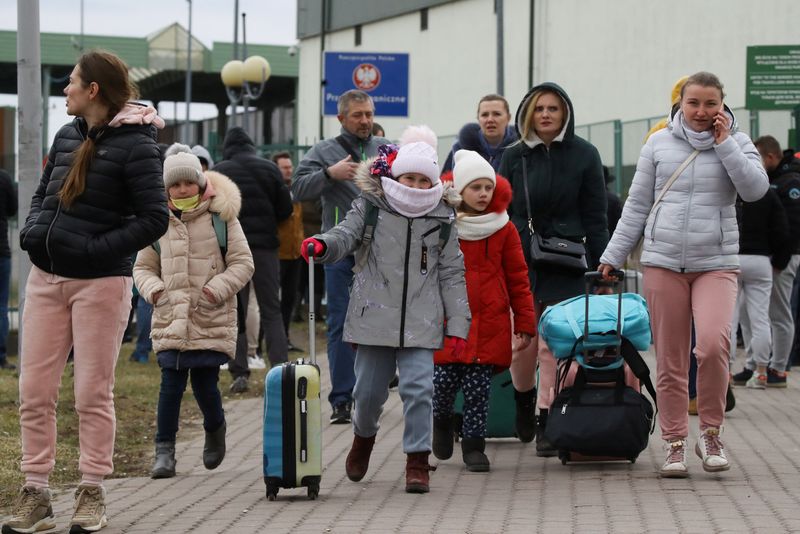 © Reuters. أشخاص يصلون لمعبر حدودي بين بولندا وأوكرانيا في ميديكا ببولندا يوم الجمعة عقب بدء عملية عسكرية روسية في أوكرانيا. تصوير:كاسير بيمبل-رويترز.