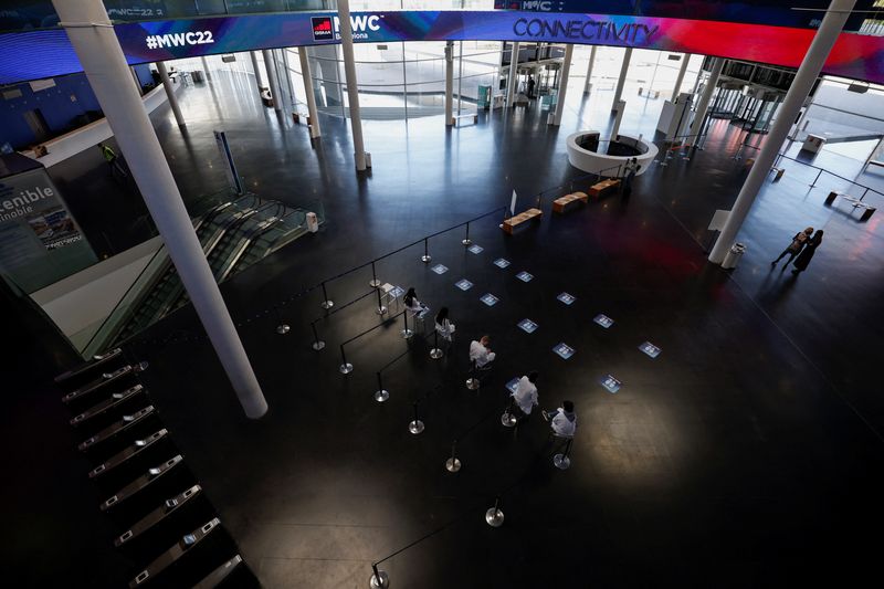 &copy; Reuters. Staff members wait to check coronavirus disease (COVID-19) vaccine QR codes at the entrance to the venue of GSMA's 2022 Mobile World Congress (MWC), scheduled to start on February 28, in Barcelona, Spain, February 10, 2022. REUTERS/Albert Gea