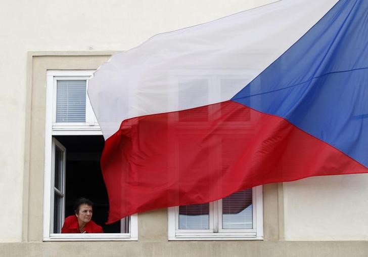 &copy; Reuters. A woman looks out from a window as a Czech Republic flag flutters in the wind, in Prague July 8, 2008.  The United States and the Czech Republic signed a treaty on Tuesday allowing Washington to build part of a missile defence shield in the central Europe