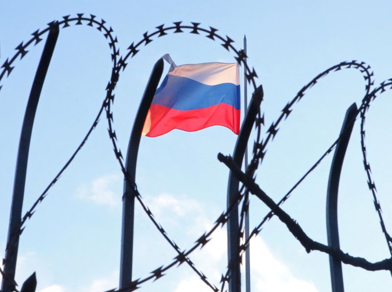 &copy; Reuters. The Russian flag is seen behind a razor wire fence on the roof of the Russian Consulate General in Kharkiv, Ukraine February 23, 2022. REUTERS/Vyacheslav Madiyevskyy