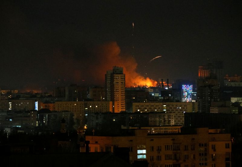 &copy; Reuters.  ２月２６日、ウクライナ軍によると、首都キエフの基地がロシア軍の攻撃を受けたものの撃退した。写真はキエフ近郊で、ロシア軍の攻撃を受けて上がる火の手（２０２２年　ロイター/Gleb