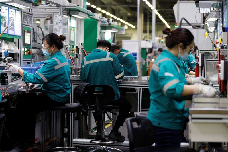 &copy; Reuters. FILE PHOTO: Employees work on the production line during an organised media tour to a Schneider Electric factory in Beijing, China February 17, 2022. REUTERS/Florence Lo