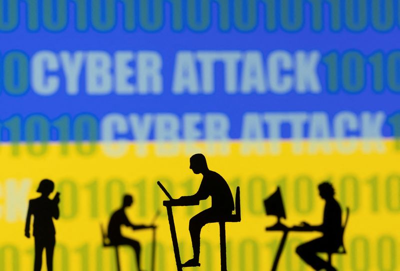 &copy; Reuters. Figurines with computers and smartphones are seen in front of the words "Cyber Attack", binary codes and the Ukrainian flag, in this illustration taken February 15, 2022. REUTERS/Dado Ruvic/Illustration/Files