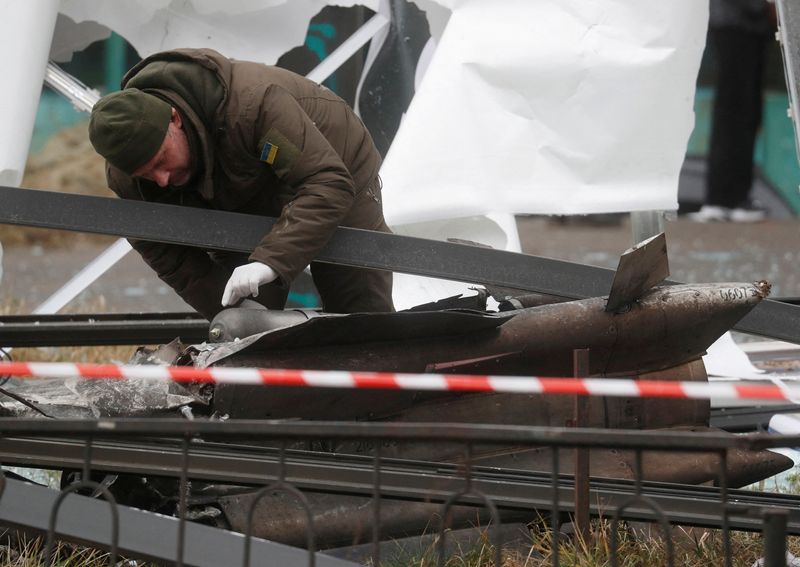 &copy; Reuters. شرطي يتفقد حطام صاروخ سقط في الشارع في كييف يوم 24 فبراير شباط 2022. تصوير فالنتاين اوجيرينكو- رويترز.