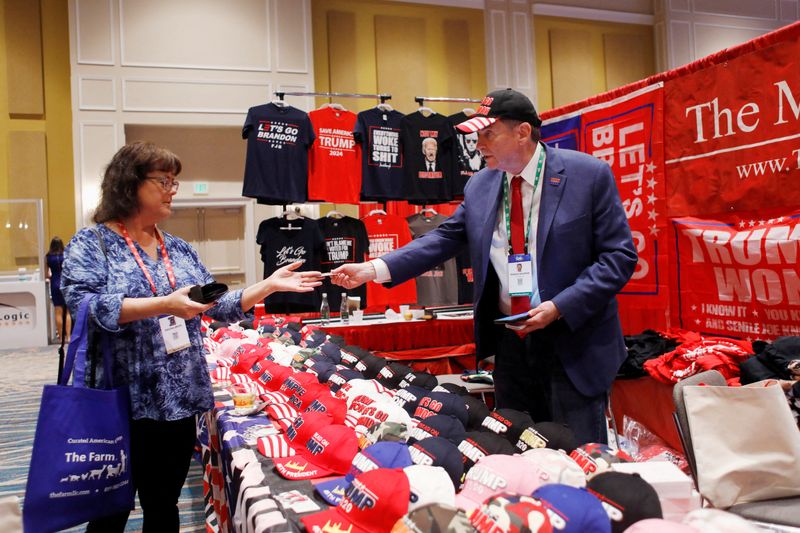 &copy; Reuters. FILE PHOTO: MAGA Mall President Ronald Solomon sells merchandise to Regina Grier at his vendor booth at the Conservative Political Action Conference (CPAC) in Orlando, Florida, U.S. February 26, 2022. REUTERS/Octavio Jones/File Photo