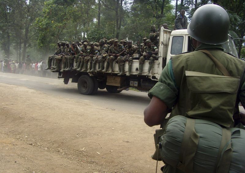&copy; Reuters. Un soldado congoleño observa un camión que transporta soldados ruandeses a través de la ciudad de Rutshuru, en la provincia congoleña de Kivu Norte, devastada por la violencia, el 24 de enero de 2009. Imagen tomada el 24 de enero de 2009. REUTERS/Stri