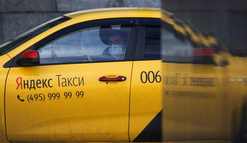 &copy; Reuters. FILE PHOTO: A driver of Yandex.Taxi online ride-sharing service wearing a protective mask, used as a preventive measure against the coronavirus disease (COVID-19), sits inside a car in Moscow, Russia April 12, 2020. REUTERS/Maxim Shemetov