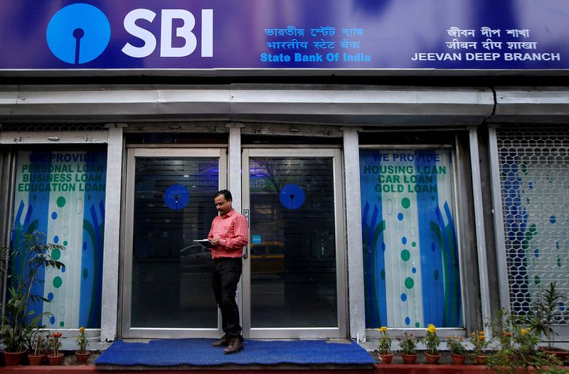 &copy; Reuters. FILE PHOTO: A man checks his mobile phones in front of State Bank of India (SBI) branch in Kolkata, India, February 9, 2018. REUTERS/Rupak De Chowdhuri