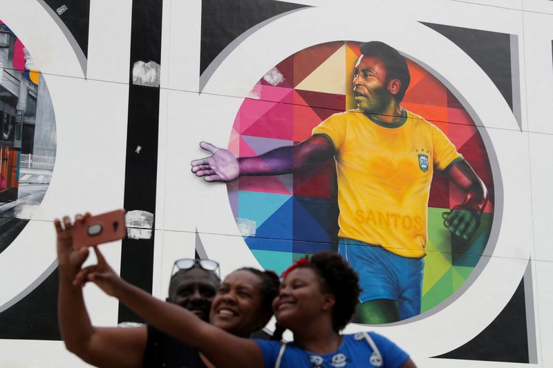 &copy; Reuters. FOTO DE ARCHIVO: Gente se toma una foto cerca de un mural que representa a la leyenda del fútbol brasileño Pelé en Santos, Brasil. 20 de octubre de 2020. REUTERS/Amanda Perobelli