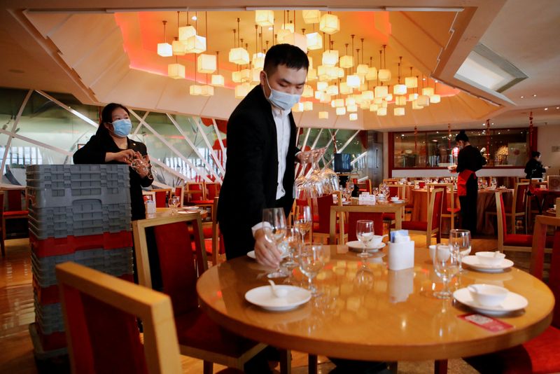 &copy; Reuters. Staff members set the tables before the Lunar New Year's Eve dinner service at The Red Chamber restaurant in Beijing, China January 31, 2022. REUTERS/Florence Lo