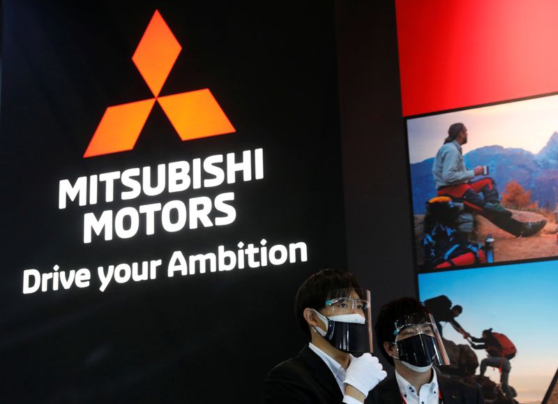 &copy; Reuters. Staff members wearing protective masks and face shields, amid the coronavirus disease (COVID-19) pandemic, stand in front of the logo of Mitsubishi Motors at Tokyo Auto Salon 2022 at Makuhari Messe in Chiba, east of Tokyo, Japan January 14, 2022. REUTERS/