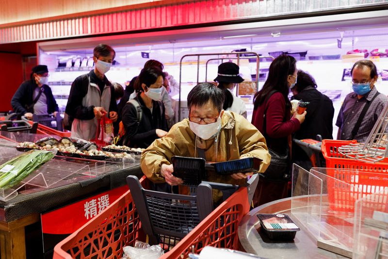 &copy; Reuters. Un cliente con mascarilla compra carne fresca en un supermercado en Hong Kong, China, 1 de marzo de 2022. REUTERS/Tyrone Siu