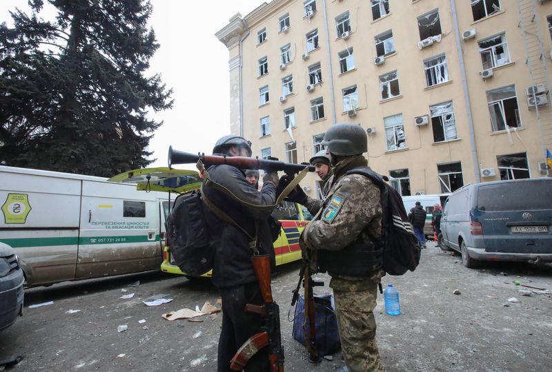 &copy; Reuters. شخصان يحملان أسلحة أمام مبنى بالإدارة الإقليمية الذي تعرض لهجوم صاروخي طبقا لما قاله مسؤولو المدينة في وسط خاركيف يوم الثلاثاء. تصوير: فيات
