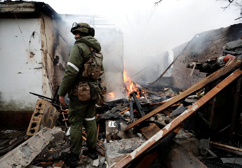&copy; Reuters. جندي موالي للميليشات المؤيدة لروسيا يقف بجوار منزل اندلعت فيه النار بعدما تعرض للقصف في مدينة دونيتسك التي يسيطر عليها الانفصاليون يوم الا