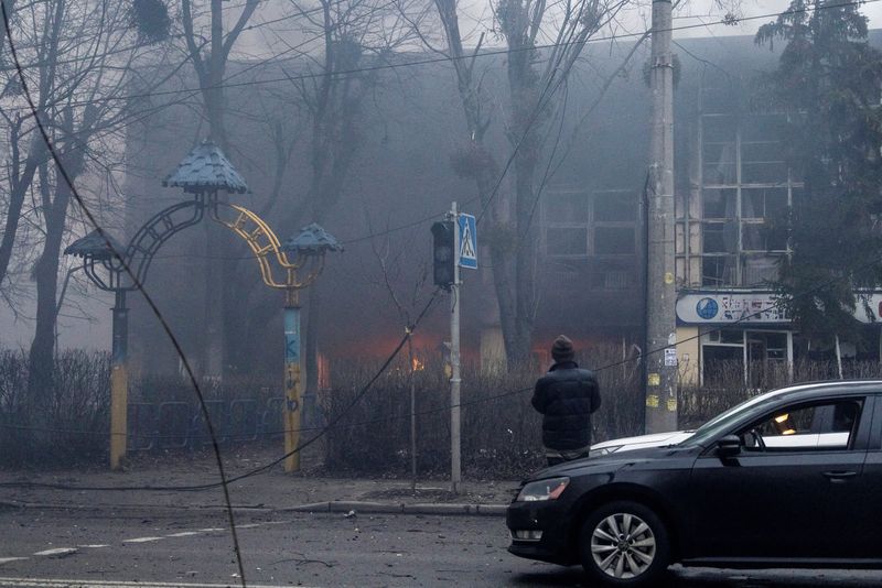 © Reuters. رجل يقف خارج مبنى تعرض للقصف في كييف يوم الثلاثاء. تصوير: كارلوس باريا - رويترز