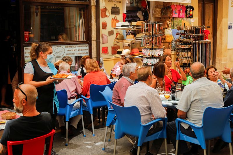 &copy; Reuters. FOTO DE ARCHIVO: Una camarera sirve comida a los clientes en la terraza de un bar en el centro de Ronda