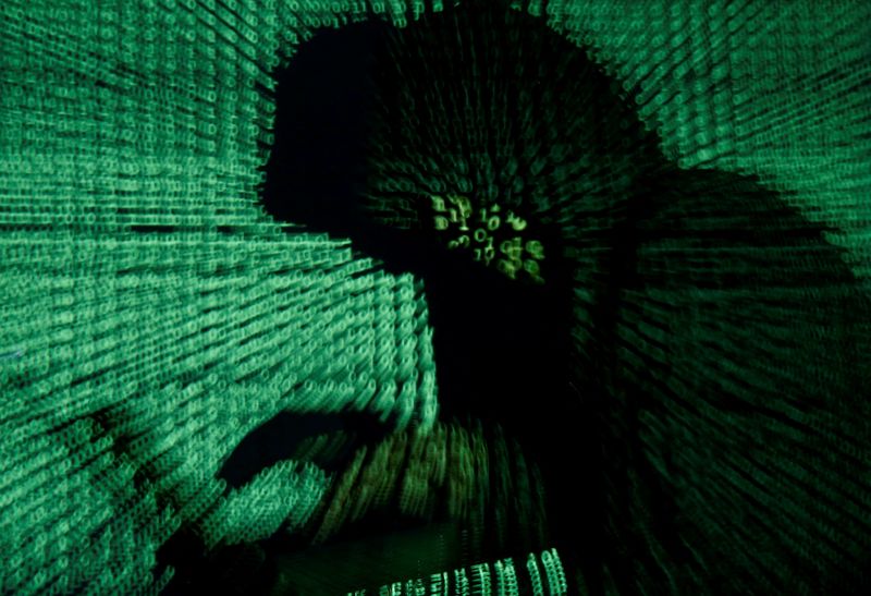 &copy; Reuters. FOTO DE ARCHIVO: Un hombre sostiene un ordenador portátil mientras se proyecta un código cibernético sobre él en esta foto de ilustración tomada el 13 de mayo de 2017. REUTERS/Kacper Pempel/Ilustración/